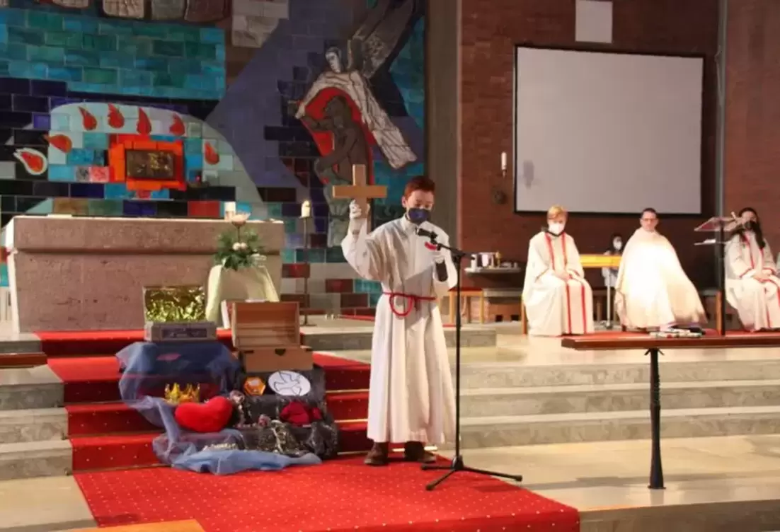 Ministrant steht bei der Ministrantenaufnahme vor dem Altar
