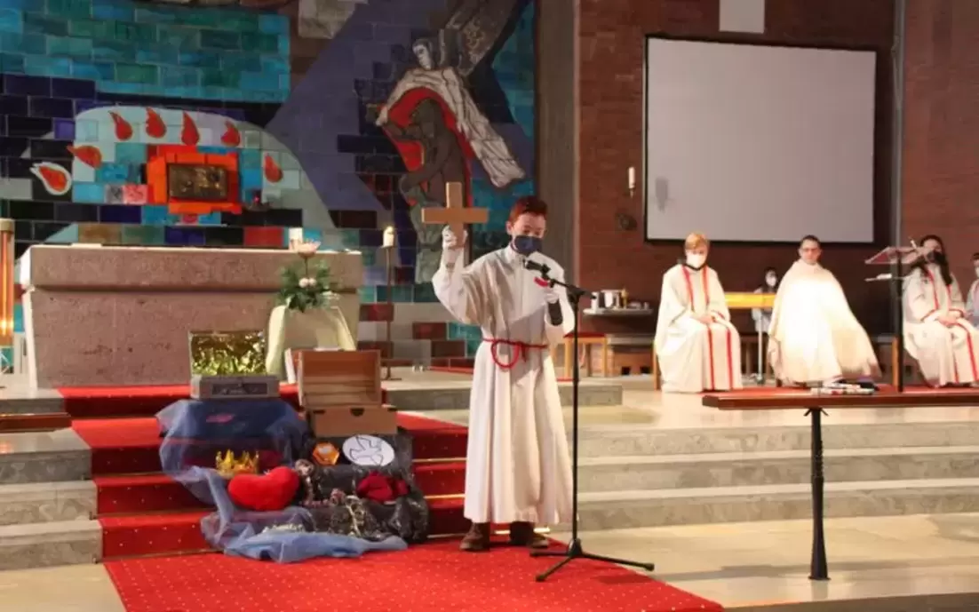 Ministrant steht bei der Ministrantenaufnahme vor dem Altar