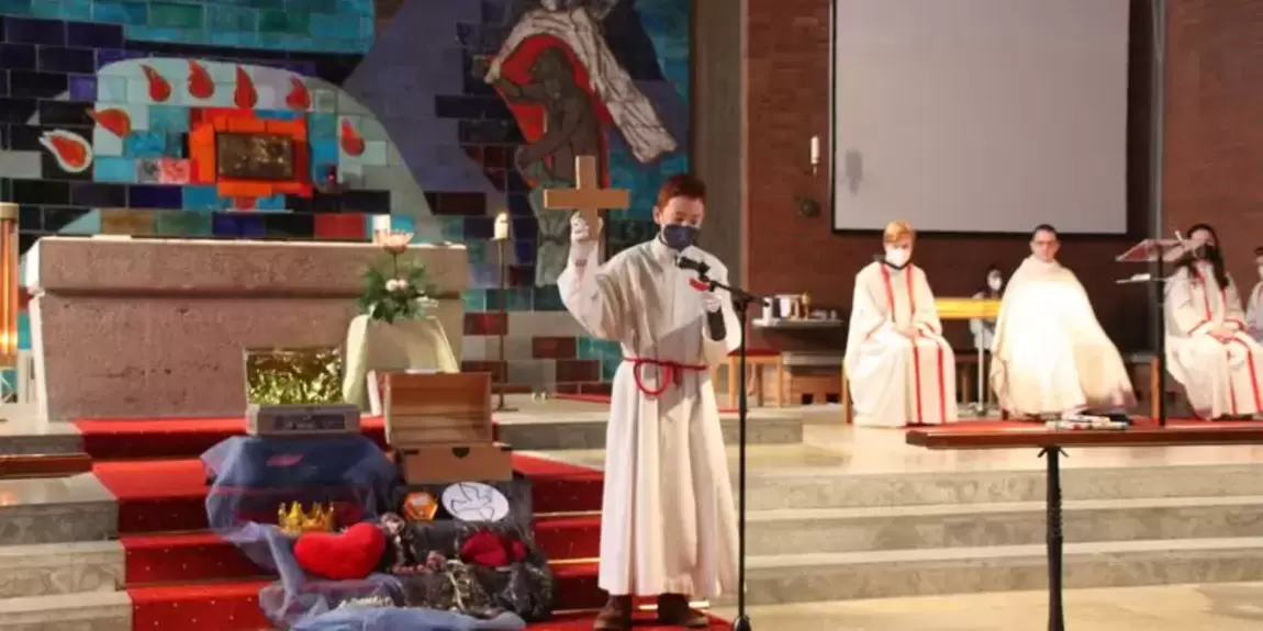 Ministrant steht bei der Ministrantenaufnahme vor dem Altar
