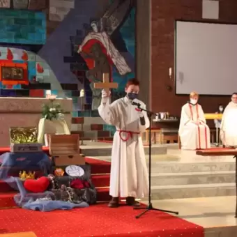 Ministrant steht bei der Ministrantenaufnahme vor dem Altar